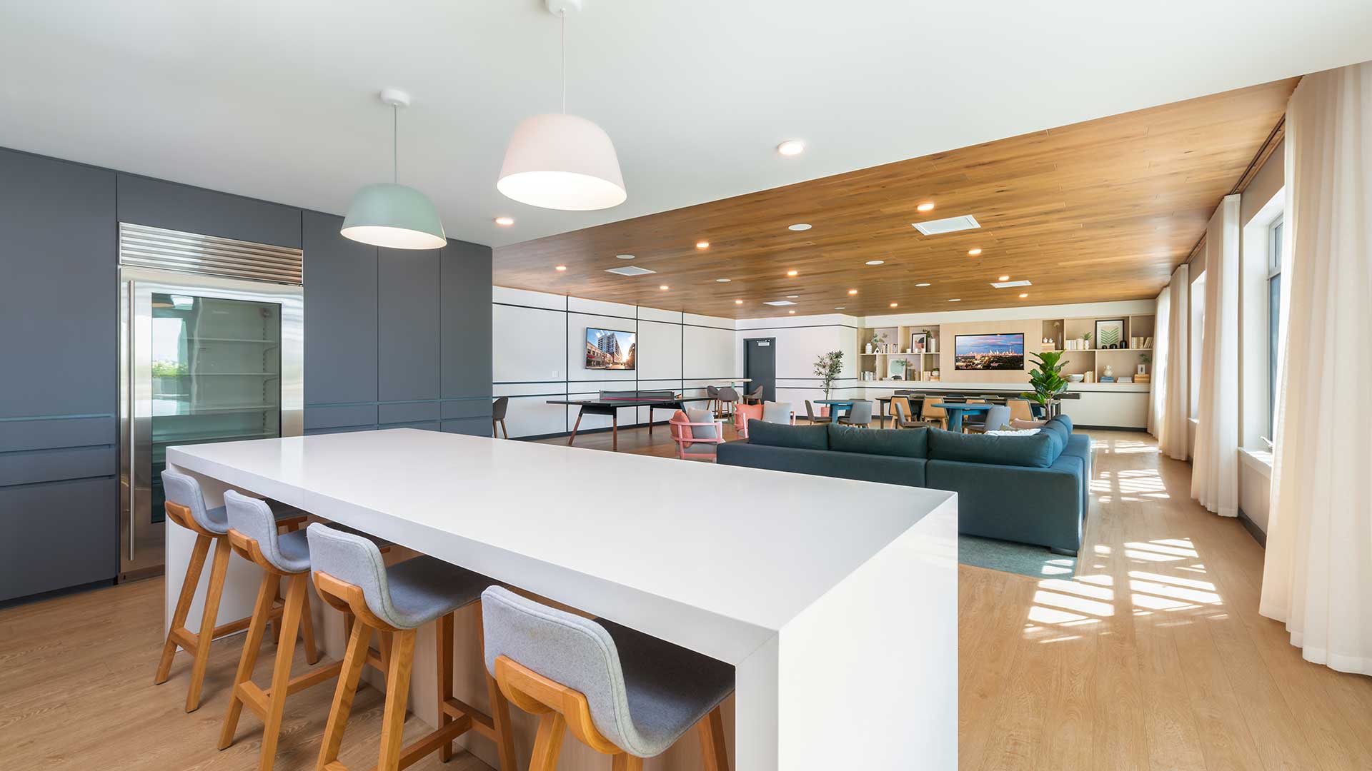 Spacious resident lounge and community kitchen at Eleven33 Apartments in Oak Park featuring modern seating, large island, and natural light-filled windows.