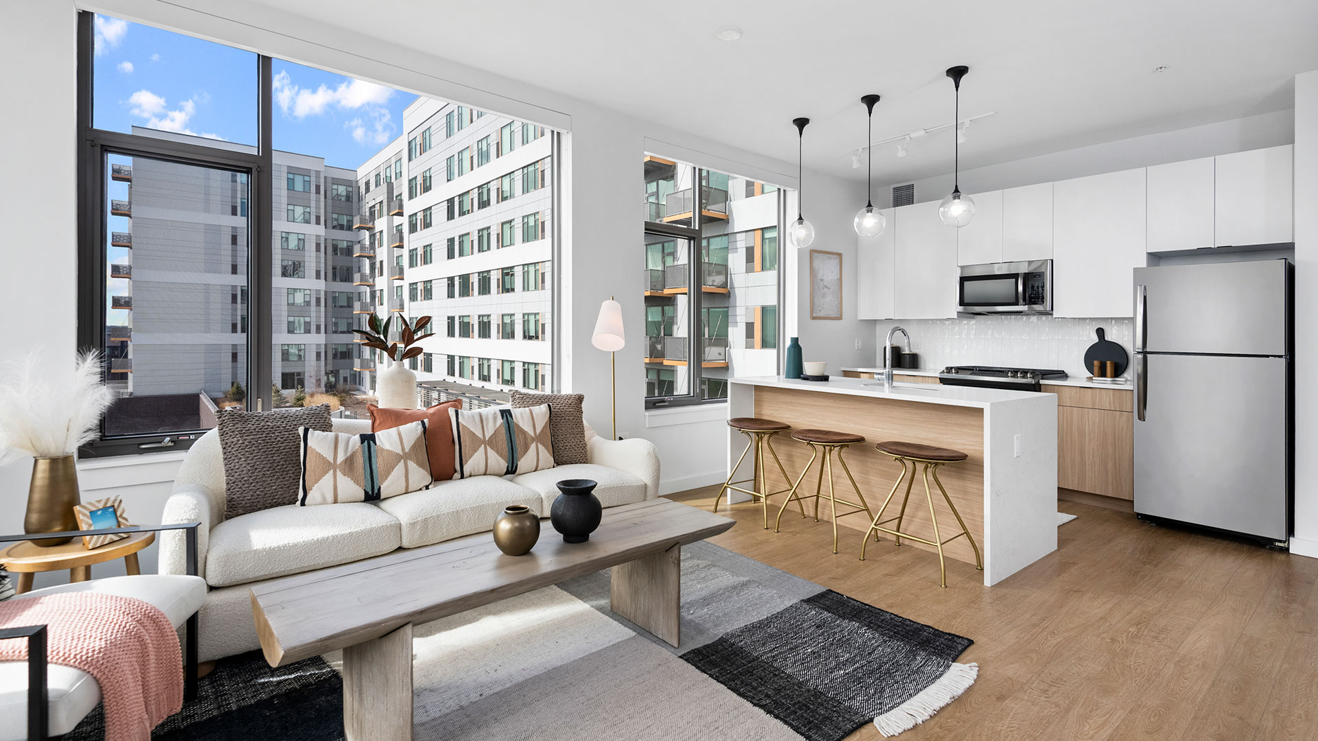 Open-concept Oak Park apartment at Eleven33 with modern kitchen, bar seating, and bright living area.